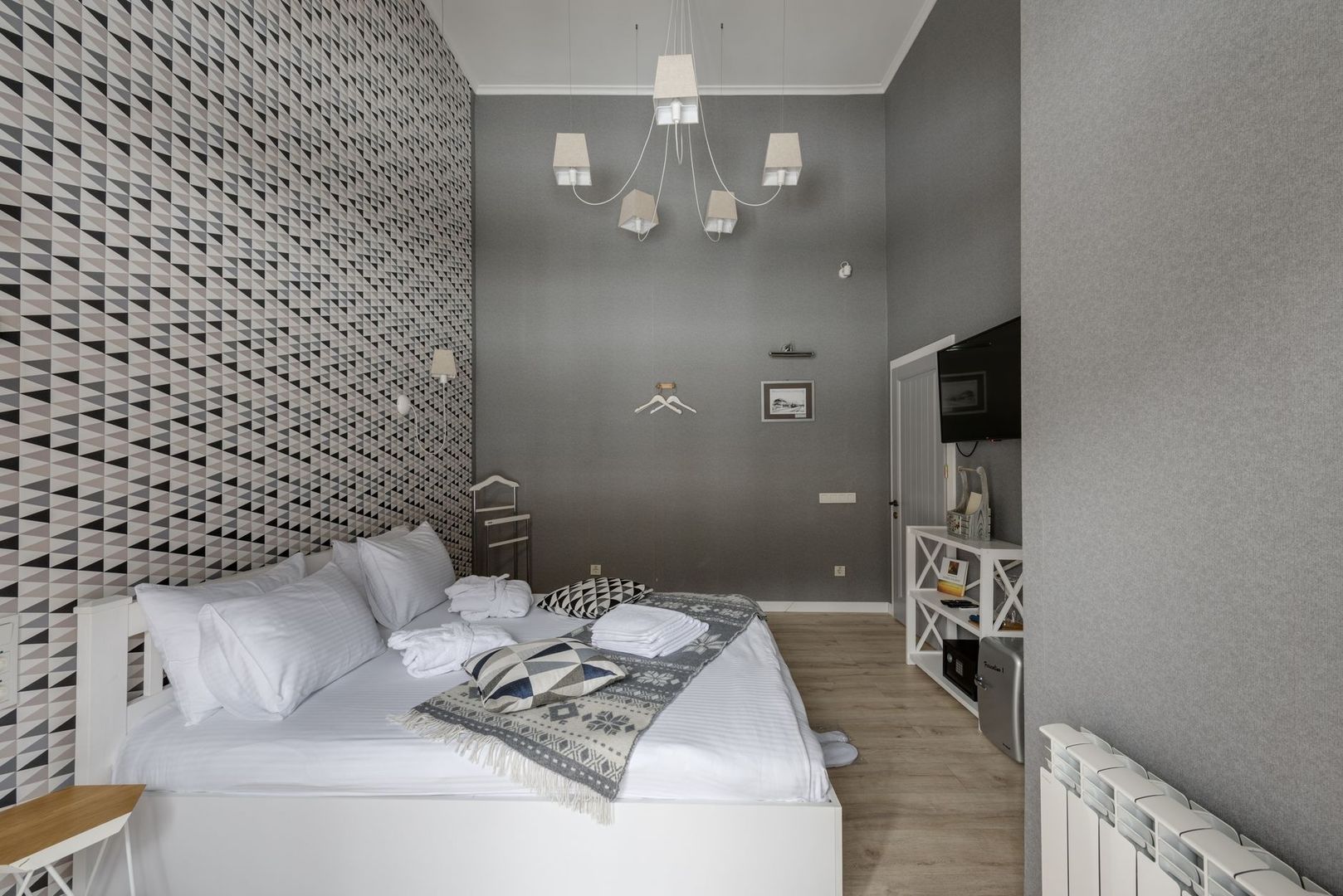 Quiet-looking boutique hotel bedroom with patterned wall and soft furnishings